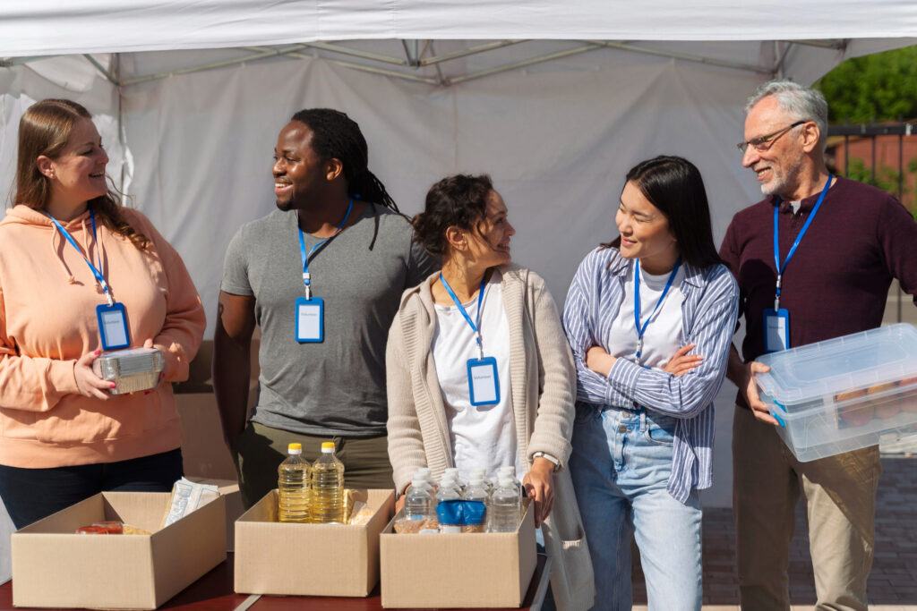 a group of people standing next to boxes of food