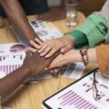 a group of people putting their hands together - rhinobay energy